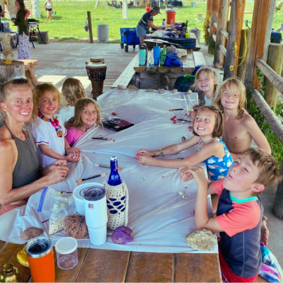 Children sharing lunch together at a picnic table at Wo-Man-I-Fest Kids' Camp